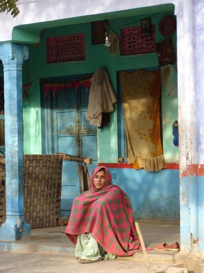 Femme assise devant sa maison