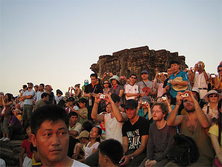 Touristes prenant en photo le coucher du soleil sur Angkor depuis le Phnom Bakheng 