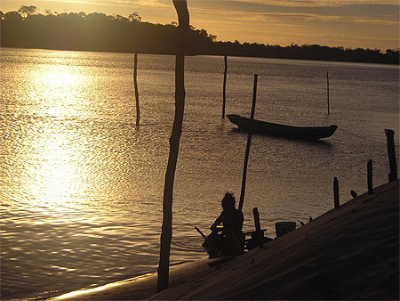 Coucher de soleil et femme lavant son linge