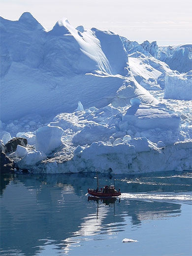 Bateau de p�cheur devant un iceberg g�ant au Groenland 